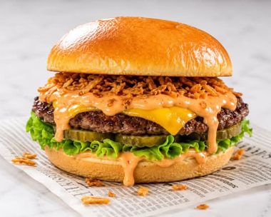 Cheesy Smash Burger: smashed rundsvleesburger met gesmolten cheddar, augurk en crispy uitjes